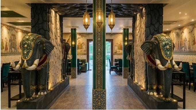 Rasa Raya dining hall with emerald green pillars, hanging brass lanterns and painted murals